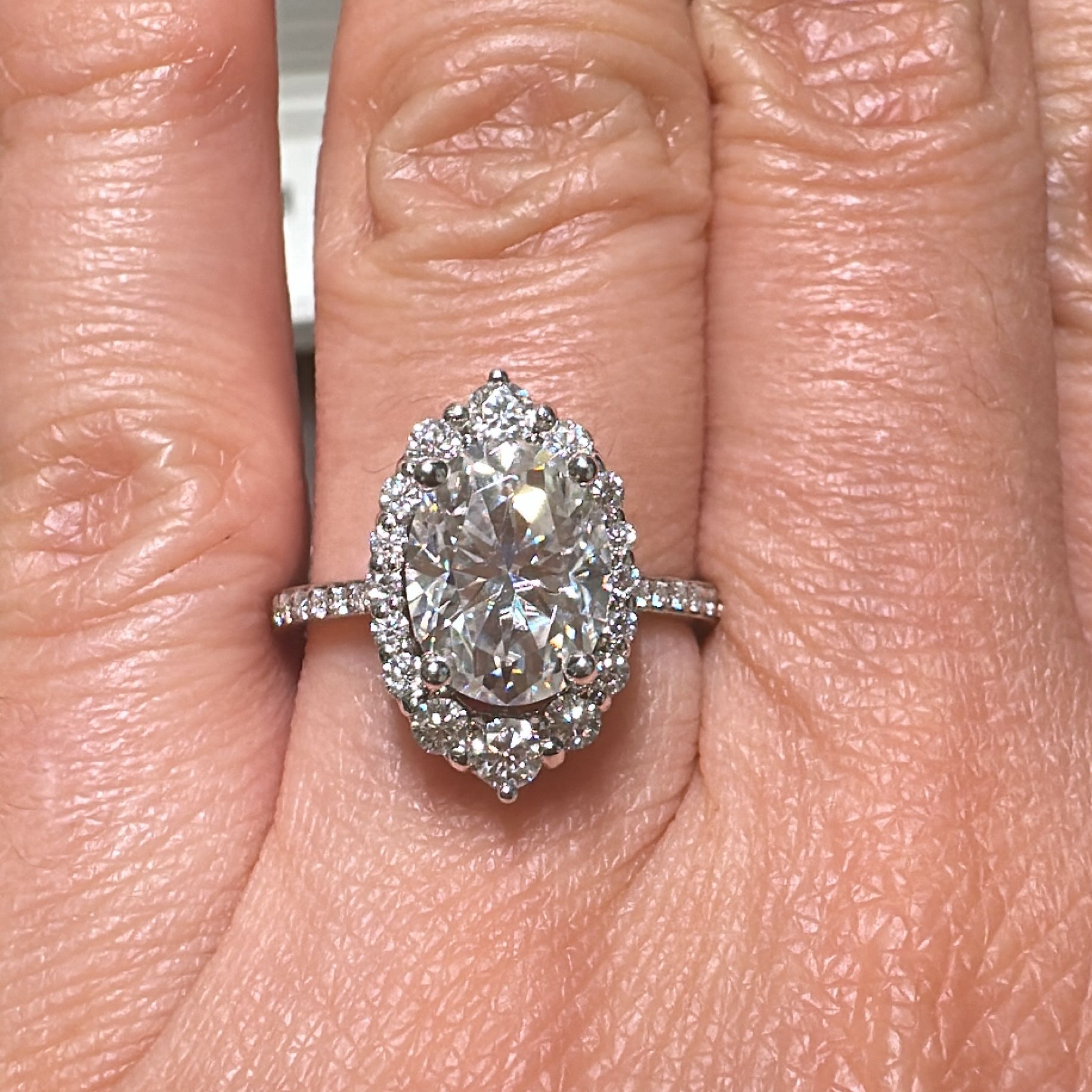 2.5 CT oval moissanite halo engagement ring in 14K gold with small moissanites.
