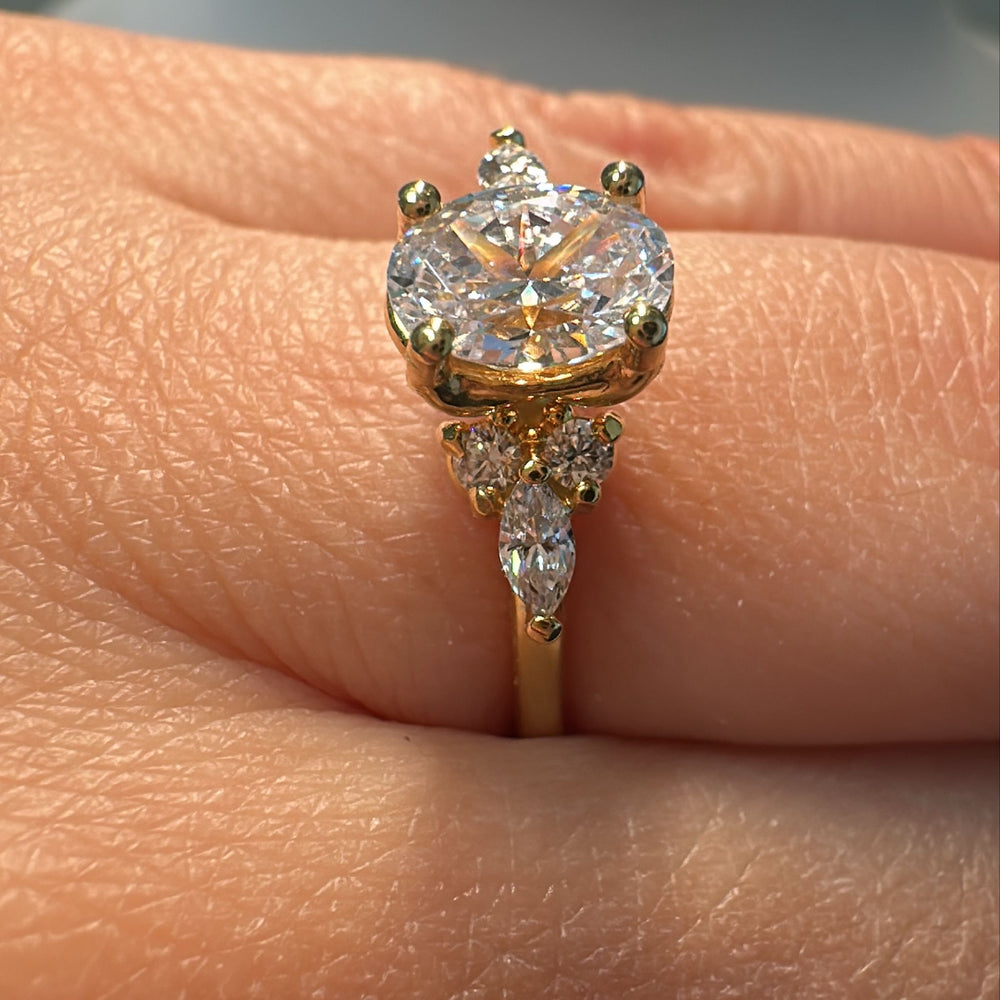 1 CT oval moissanite engagement ring in 14K gold with small moissanite accents.