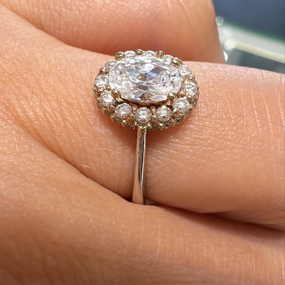 1 CT oval moissanite engagement ring with halo diamonds on 14K gold band.