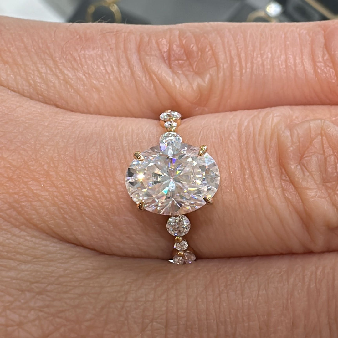 2 CT oval moissanite engagement ring with accent stones in 14K gold.