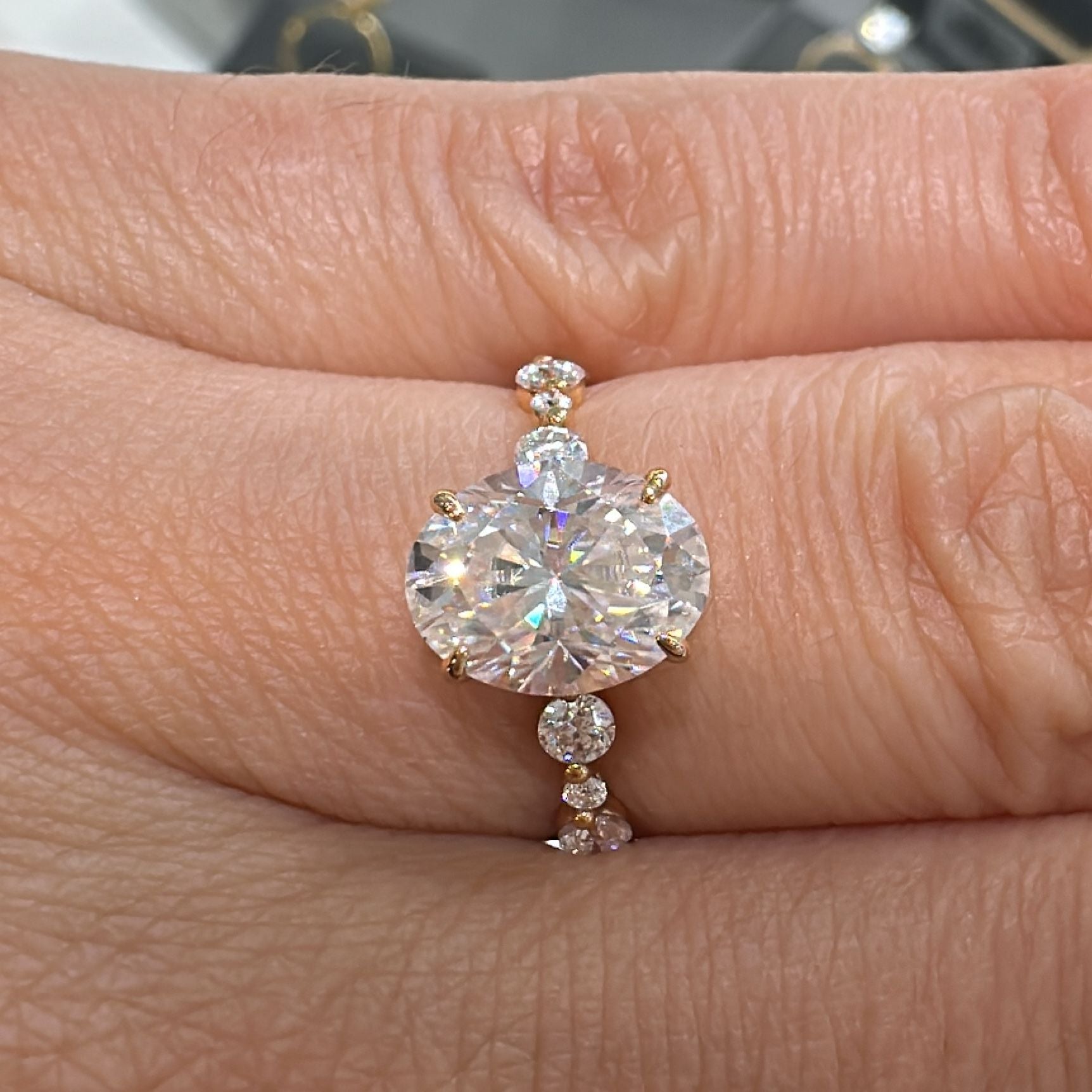2 CT oval moissanite engagement ring with accent stones in 14K gold.