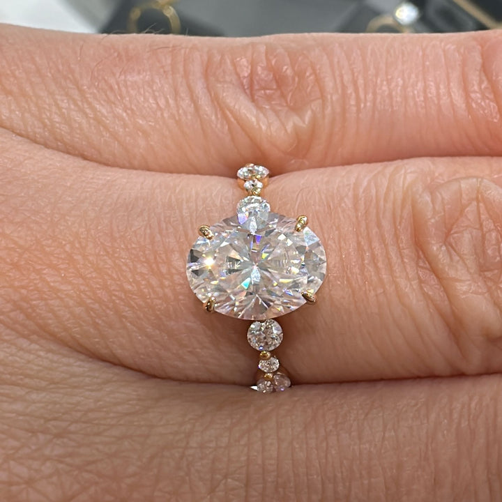 2 CT oval moissanite engagement ring with accent stones in 14K gold.