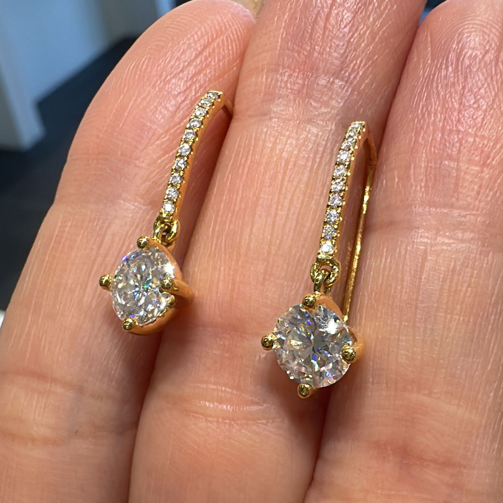 1 CT moissanite dangling earrings with small moissanite accents in 14K gold.