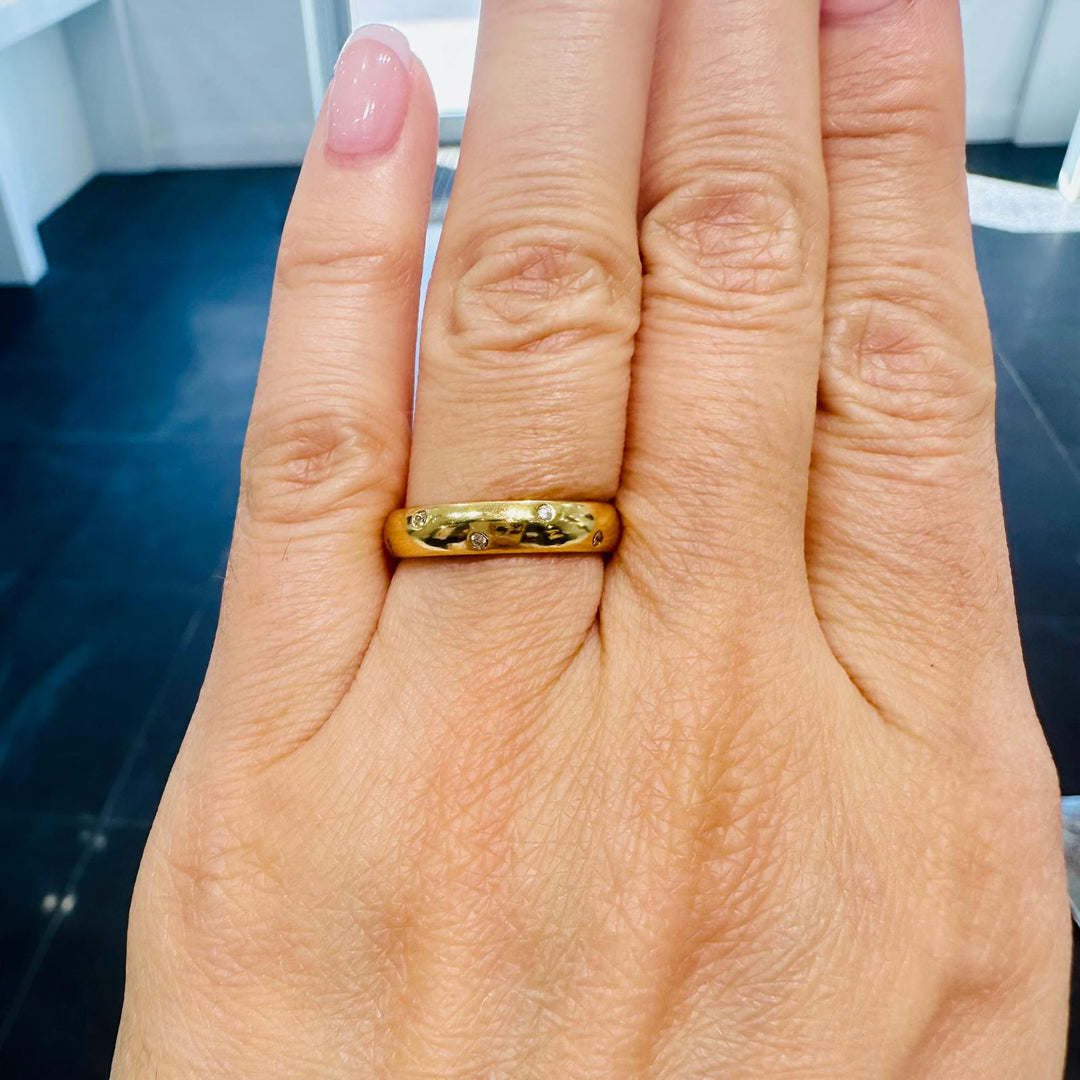 4mm 14K gold wedding band with scattered round diamonds on hand