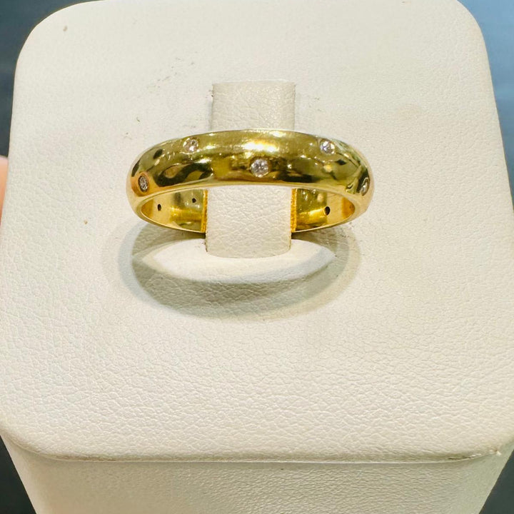 4mm 14K gold wedding band with scattered round diamonds on hand