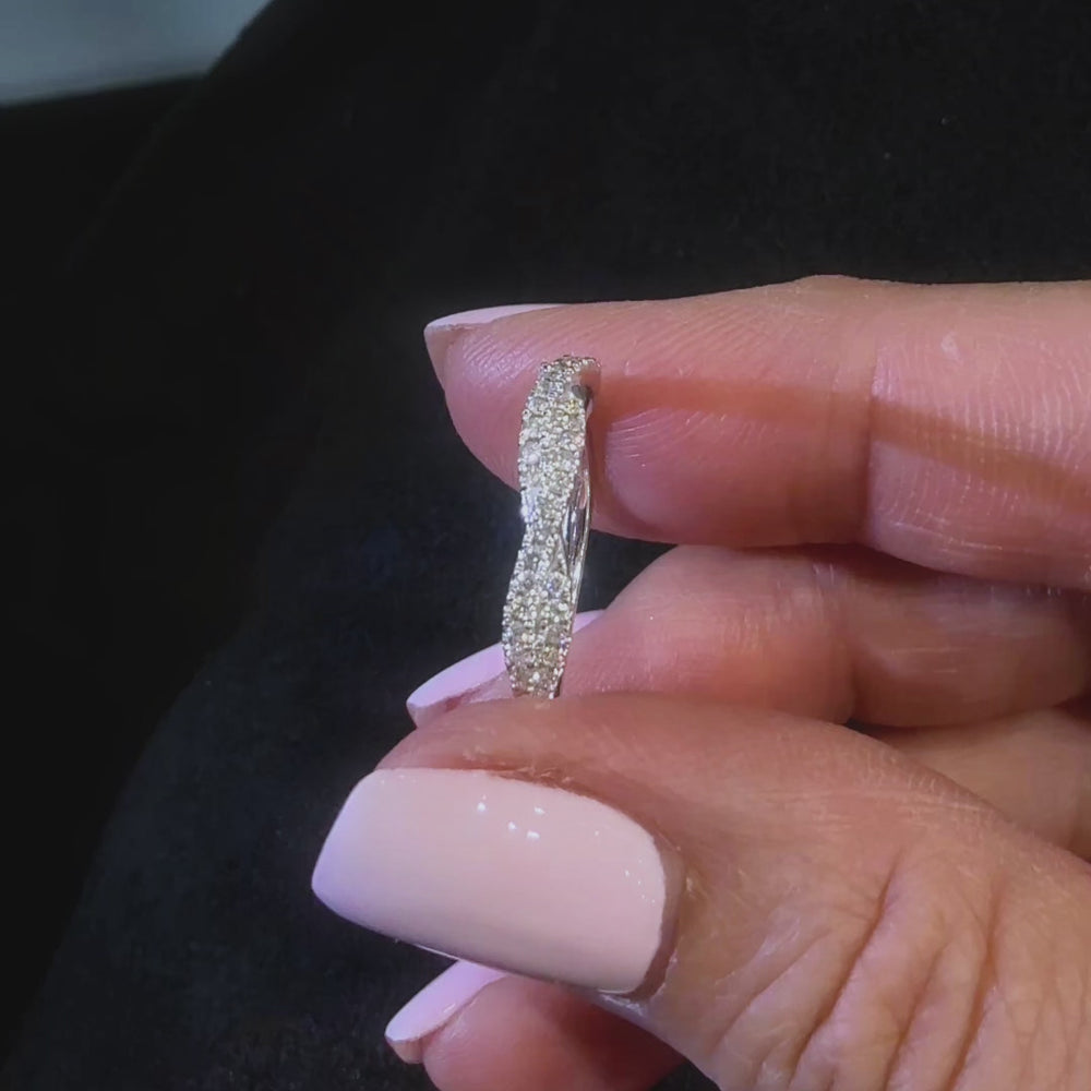 twisted diamond wedding band held between fingers